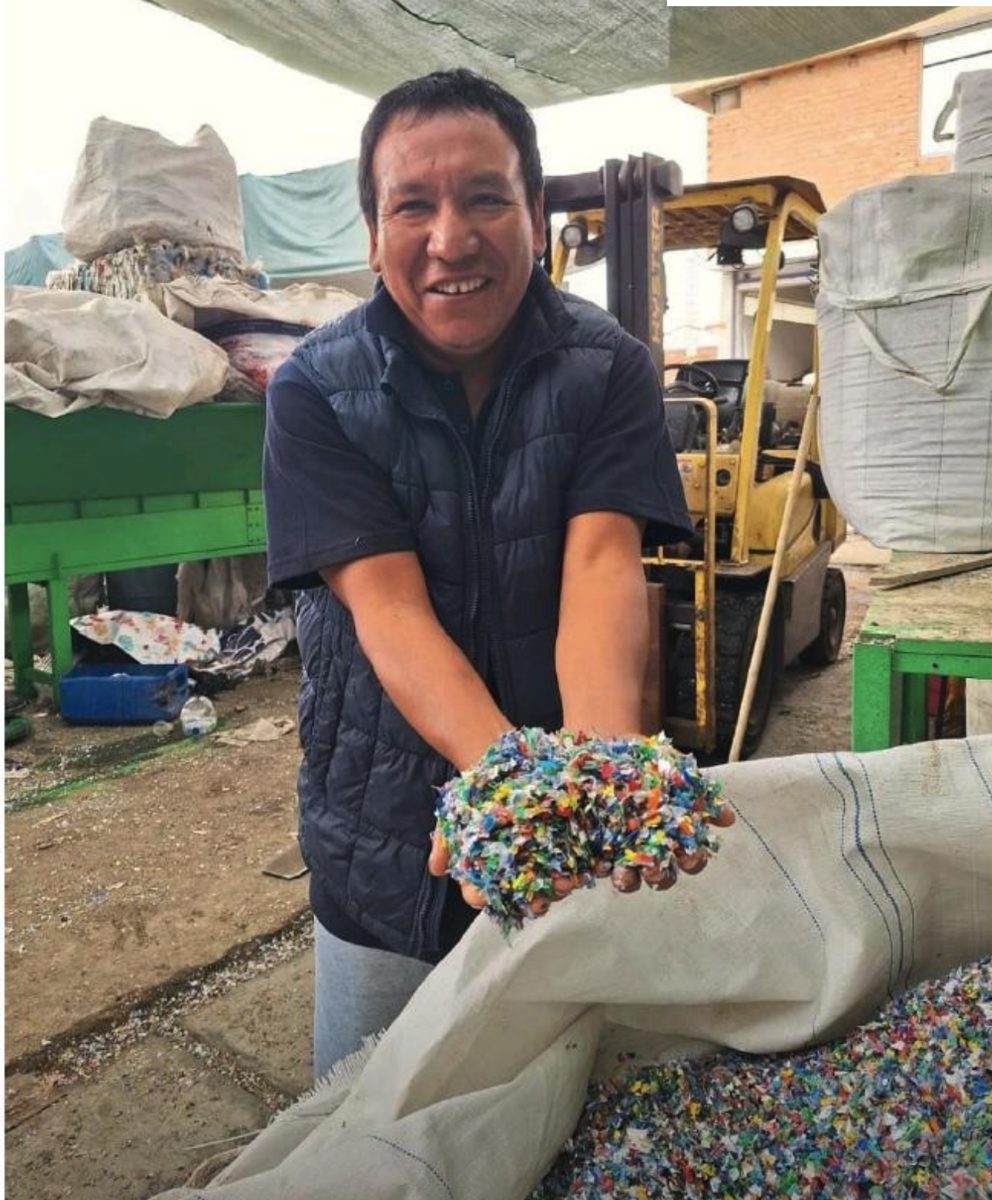 Un reciclador muestra en sus manos plástico recuperado y triturado, listo para volver a la industria